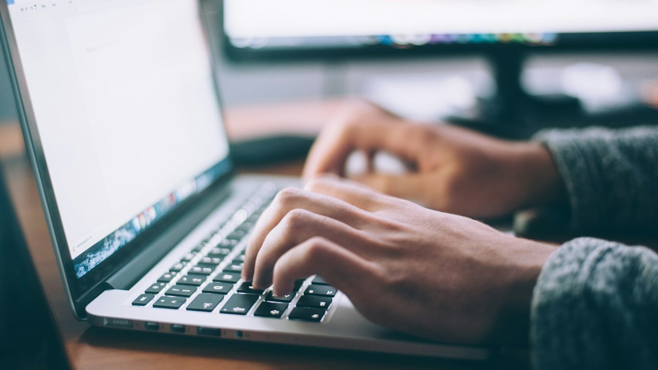 Orang mengetik di laptop untuk cara membuat email bisnis dengan domain sendiri