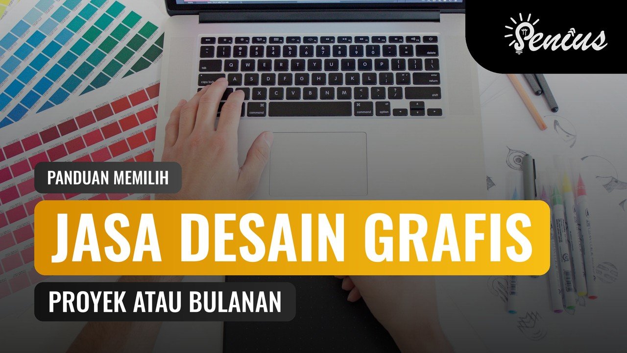 Desainer menggunakan laptop dan tablet gambar di meja dengan palet warna untuk jasa desain grafis